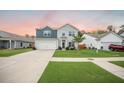 Two-story home featuring blue and gray siding, a spacious driveway, and a well-manicured lawn at 141 Pine Crest View Dr, Summerville, SC 29486