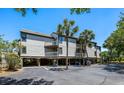 Beige condo building on stilts with parking underneath and mature palm trees at 1605 Live Oak Park, Seabrook Island, SC 29455