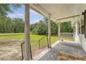 Covered front porch has a porch swing, columns, and brick steps at 2202 Sc-61, Ridgeville, SC 29472