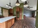Spacious kitchen with an island, wood cabinets, unique lighting fixtures, and hard wood floors at 2204 Dover St, North Charleston, SC 29405