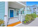 Inviting front porch featuring a blue door with wreath, white railings, and manicured landscaping at 2336 Brinkley Rd, Johns Island, SC 29455