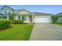A cozy single-story house with a green lawn and an attached garage, ideal for a small Gathering or downsizing at 254 Mayfield Dr, Goose Creek, SC 29445
