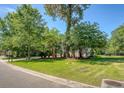 Landscaped front yard with lush greenery and mature trees surrounding the house at 2701 Fountainhead Way, Mount Pleasant, SC 29466