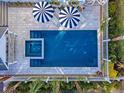 Aerial view of a backyard pool with striped umbrellas and lounge chairs on a tiled patio at 304 Bank St, Mount Pleasant, SC 29464