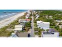 Expansive aerial view of a coastal community with beach access, showcasing a mix of homes and lush greenery at 313 E Arctic Ave, Folly Beach, SC 29439
