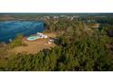 Aerial view of a lakeside community with pool, clubhouse, and surrounding trees at 325 Hillman Trail Dr, Moncks Corner, SC 29461