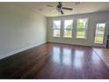Bright living room featuring gleaming hardwood floors, large windows, and a ceiling fan at 3254 Hartwell St, Johns Island, SC 29455