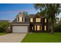 Exterior view of a brick home at twilight, showcasing illuminated windows and landscaped yard at 3290 Middleburry Ln, Charleston, SC 29414