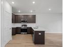 A modern kitchen featuring stainless steel appliances, dark brown cabinets, and a center island at 335 Bremerton Dr, Goose Creek, SC 29445