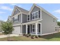 Side angle view showcasing the home's gray siding, white trim, and a well-kept lawn at 357 Hillman Trail Dr, Moncks Corner, SC 29461