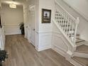 Welcoming entryway features wood-look floors, white wainscoting, and a staircase at 4013 Conant Rd, Mount Pleasant, SC 29466