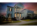 Inviting two-story home with double porches, illuminated by warm exterior lighting at 403 Cool Bend Ln, Summerville, SC 29486