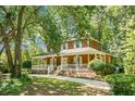 Charming two-story home featuring a wide front porch with white railings, brick accents, and mature landscaping at 49 Crosscreek Dr, Charleston, SC 29412
