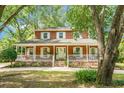 Charming two-story home featuring a wide front porch with white railings and brick accents at 49 Crosscreek Dr, Charleston, SC 29412