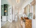 Elegant hallway featuring light hardwood floors, decorative mirror, a charming chandelier, and adjacent office space at 603 Cavour Ct, Summerville, SC 29486