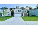 Two-story home featuring a two-car garage, gray brick accents, black shutters, with adjacent lawns at 619 Red Mulberry Rd, Moncks Corner, SC 29461