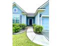 Front entrance featuring a walkway to the dark front door at 7629 High Maple Cir, North Charleston, SC 29418