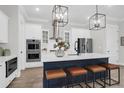 Bright kitchen featuring a large island with seating, white cabinets, and modern stainless appliances at 779 Forrest Dr, Charleston, SC 29492