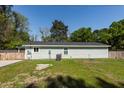 View of side of light green house, showcasing the roof, yard, fence, and AC unit at 8562 N Highway 17, McClellanville, SC 29458