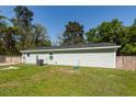 The side of the light green home reveals a pristine roof, well-kept lawn, and functional AC unit at 8562 N Highway 17, McClellanville, SC 29458