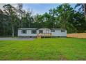 Classic one-story home with a charming wooden deck and freshly cut lawn, providing a cozy and inviting atmosphere at 117 Dairy Ln, Cottageville, SC 29435