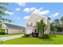 Charming two-story home with a well-maintained lawn and single car garage, complemented by lush green trees and landscaping at 1170 Deerberry Rd, Hanahan, SC 29410