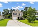 Charming two-story home with a well-maintained lawn and driveway, complemented by lush green trees and landscaping at 1170 Deerberry Rd, Hanahan, SC 29410