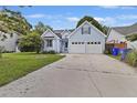 Charming light blue two-story home with attached two-car garage, well-maintained lawn, and sunny skies at 1245 Lakefront Drive Dr, Charleston, SC 29412