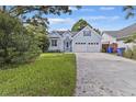 Charming light blue home with attached two-car garage, well-manicured lawn, and blue skies at 1245 Lakefront Drive Dr, Charleston, SC 29412