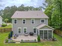 A peaceful backyard featuring a patio with outdoor furniture, grills, and lush greenery at 125 Beam St, Huger, SC 29450