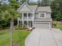 Elegant two-story home showcasing a spacious driveway, well-manicured lawn and double stacked porches at 125 Beam St, Huger, SC 29450
