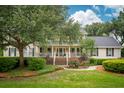 Traditional home with a well-maintained lawn, mature trees, and inviting front porch at 1511 Fairway Dr, Charleston, SC 29412