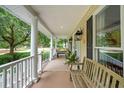 Inviting front porch featuring classic columns, neutral color scheme, and comfortable seating options at 1511 Fairway Dr, Charleston, SC 29412