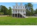 Beautiful white home with a spacious front yard and inviting porch at 1577 Periwinkle Dr, Mount Pleasant, SC 29466