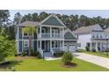 Inviting two-story home with a charming porch, lush lawn, and a well-manicured landscape at 183 Calm Water Way, Summerville, SC 29486