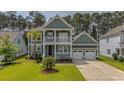 Charming home featuring a lush front lawn and a spacious two-car garage with a double driveway at 183 Calm Water Way, Summerville, SC 29486