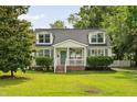 Inviting cape cod featuring a front porch,dormers, and manicured lawn at 19 Avondale Ave, Charleston, SC 29407