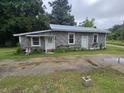 A gray block home with a metal roof, small yard, and two entry doors at 2200 State Road Rd, Summerville, SC 29486
