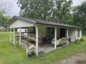 Covered back porch with swing bench adding a cozy spot to relax outdoors at 2200 State Road Rd, Summerville, SC 29486