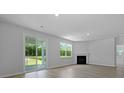 Spacious living room boasts hardwood floors, a fireplace, and sliding doors to the outdoors at 222 Seele St, Summerville, SC 29485