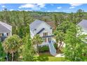 Aerial view of a charming two-story home nestled among lush trees near a marshland and golf course at 2301 N Creek Dr, Mount Pleasant, SC 29466