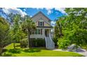 Charming two-story home with well-maintained lawn, mature trees, and front entrance accessible by stairs at 2301 N Creek Dr, Mount Pleasant, SC 29466