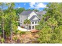 Rear aerial view of home with back porch, lower level garage, and mature trees at 2301 N Creek Dr, Mount Pleasant, SC 29466