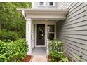 Charming home entrance featuring a black front door, white columns, and lush landscaping at 2688 Jacana Ct, Mount Pleasant, SC 29466