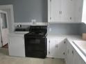 Functional kitchen with black oven and washer dryer next to a white sink at 301 Ridge St, Saint George, SC 29477