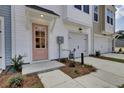 Charming townhome entrance with a pink door and a single car garage for easy access at 424 Caledon Ct, Johns Island, SC 29455
