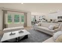 Bright and airy living room boasts a neutral color palette and access to the kitchen and dining area at 424 Radiant Blue Way, Summerville, SC 29486
