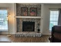 Cozy living area highlighting a stone fireplace with mantle, flanked by light-filled windows at 514 Woodward Blvd, Summerville, SC 29483