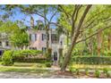 Two-story pink home behind a lush fence line and mature trees at 62 Eastlake Rd, Mount Pleasant, SC 29464