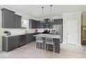 Modern kitchen with stainless steel appliances, marble countertop island with bar stools and gray cabinets at 724 Meadowbrook Ln, Summerville, SC 29486